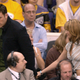 Ben Affleck holds Jennifer Lopez's hand as the two walk through the crowd of a Lakers game in 2003